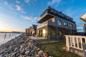 a house on the shore of a body of water at Jazz ArT's Penthouse in Olpenitz