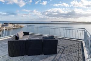 a couch on a balcony with a view of the water at Jazz ArT's Penthouse in Olpenitz
