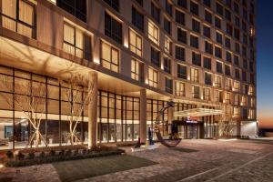 金浦Ramada Encore by Wyndham Gimpo Han River Hotel的前面有雕塑的建筑