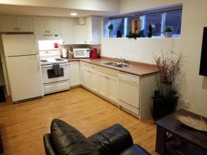 eine Küche mit weißen Geräten und einer Couch darin in der Unterkunft Roche Bonhomme Rustic Suite in Jasper