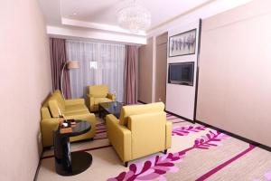 una camera d'albergo con sedie gialle e un soggiorno di Lavande Hotel (Foshan Shunde Shunlian Square) a Shunde