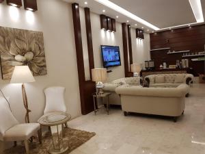 a living room with couches and a flat screen tv at Waqet AlFakhama Furnished Apartments in Tabuk