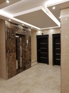 塔布克的住宿－Waqet AlFakhama Furnished Apartments，客房设有2扇黑色门,铺有瓷砖地板。