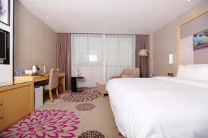 una camera d'albergo con letto e scrivania di Lavande Hotel (Foshan Shunde Shunlian Square) a Shunde
