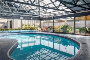 een binnenzwembad in een gebouw met een glazen plafond bij Barclay Motor Inn in Devonport