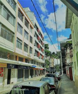 a street with cars parked in front of buildings at Frente Praca Principal Friburgo a 200 metros do Teleferico in Nova Friburgo