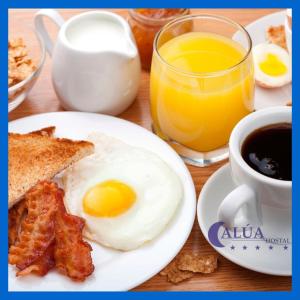 a breakfast plate with eggs and bacon and a cup of coffee at Hostal Alua Rio in Quito