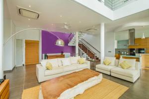uma sala de estar com dois sofás brancos e uma cozinha em Phocea Golf View Villa by Premier Hospitality Asia em Jimbaran