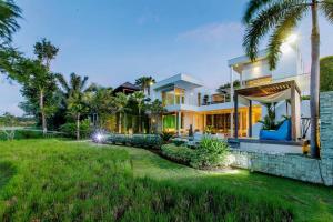 uma casa grande com um relvado em frente em Phocea Golf View Villa by Premier Hospitality Asia em Jimbaran