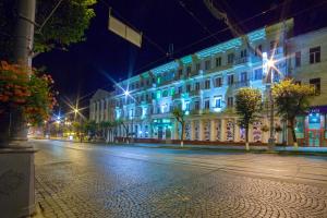 a city street at night with tall buildings at Hotel Vinnytsia Sawoy in Vinnytsya