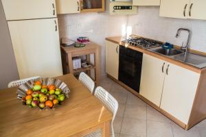 a kitchen with a table with a bowl of fruit on it at FuoriPorta Affitti Brevi - New A Casa da Ida in Parma
