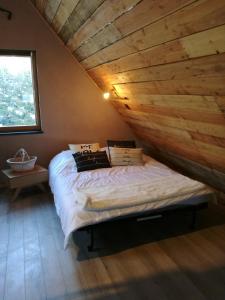 a bed in a room with a wooden ceiling at L Annexe in Mittlach