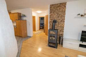 sala de estar con chimenea y pared de piedra en Ferienwohnung Ruderich, en Hirschaid