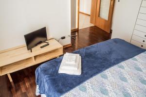 een slaapkamer met een bed en een tv op een bureau bij New A Casa da Ida in Parma