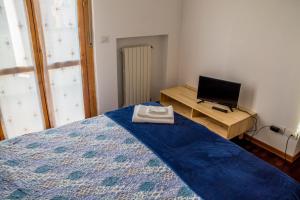 a bedroom with a bed and a desk with a television at New A Casa da Ida in Parma