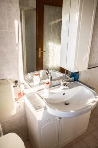 a bathroom with a white sink and a toilet at New A Casa da Ida in Parma