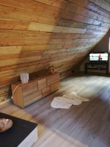 an attic room with wooden walls and a wooden floor at L Annexe in Mittlach