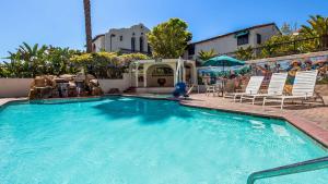 uma piscina com cadeiras e uma mesa e um edifício em Best Western Casa Grande Inn em Arroyo Grande