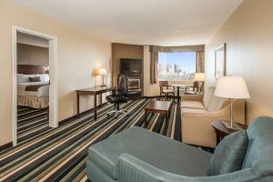 a hotel room with a couch and a bed at Best Western Plus Winnipeg Airport Hotel in Winnipeg