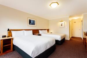a hotel room with two beds and a tv at Cradle Mountain Hotel in Cradle Mountain