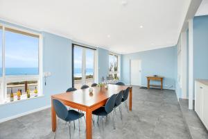 a dining room with blue walls and a table and chairs at Salomon Sea Haus - Sellicks Beach - C21 SouthCoast Holidays in Sellicks Beach