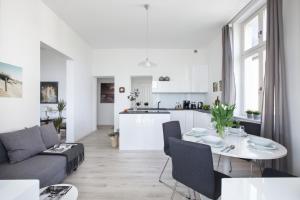 Biały salon ze stołem i kuchnią w obiekcie RJ Apartments Chopina w mieście Sopot