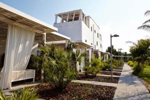 a white building with a porch and a sidewalk at La Suite Boutique Hotel in Procida +30 photos
