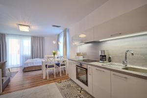 a kitchen with a sink and a room with a bed at Bliżej Morza 16 PREMIUM in Kołobrzeg