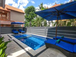 una piscina con sombrilla azul y sillas azules en Chillhouse Lembongan, en Nusa Lembongan