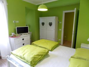 a green bedroom with two beds and a television at Appartamenti Il Vecchio Mulino in Salò