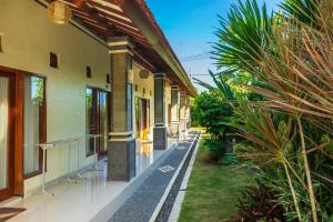 a courtyard of a house with some plants at Lilis Cempaka Mas Guesthouse in Canggu