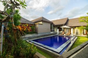 a swimming pool in the backyard of a house at Lilis Cempaka Mas Guesthouse in Canggu