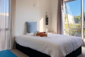 a bedroom with a bed with a stuffed animal on it at Deluxe Coastal Home & Award-winning Golf in Whangaparaoa