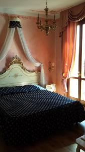 una camera da letto con un letto bianco e blu e un lampadario a braccio di Garda Sol SPA Hotel & Appartamenti a Toscolano Maderno