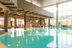 a large swimming pool with blue water in a building at Aldiana Club Ampflwang in Ampflwang im Hausruckwald