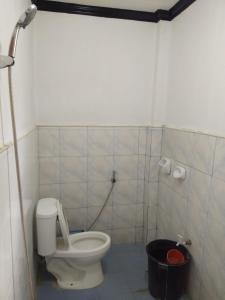 a bathroom with a toilet and a black bucket at RSK Beach and Accommodation in Dapa