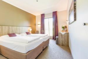 ein Hotelzimmer mit 2 Betten und einem Fenster in der Unterkunft Aldiana Club Ampflwang in Ampflwang im Hausruckwald