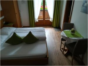 1 dormitorio con cama, mesa y ventana en Gästehaus Waldruh, en Mayrhofen