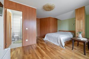 a bedroom with a bed and a bathroom at Adelės Vila in Palanga