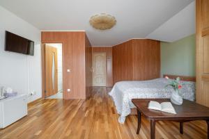 a bedroom with a bed and a table with books at Adelės Vila in Palanga