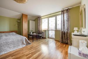 a bedroom with a bed and a table and a window at Adelės Vila in Palanga