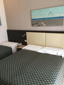 una camera d'albergo con due letti e un dipinto sul muro di Hotel Rudy Cervia a Cervia