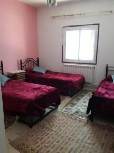 1 dormitorio con 2 camas y ventana en Residence Dayet Aoua, en Ifrane
