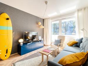 a living room with a surfboard on the wall at Apartament SURF SurfingBird Kołobrzeg in Kołobrzeg