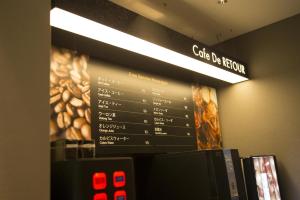 ein Schild für ein Café mit einer Speisekarte an der Wand in der Unterkunft ルトゥール難波 RetourNANBA 男塾ホテルグループ in Osaka