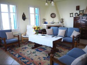 a living room with a table and blue chairs at Villa Natasa in Batsi