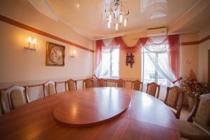 a dining room with a large wooden table and chairs at Hotel Vinnytsia Sawoy in Vinnytsya