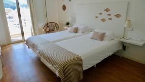 a large white bed in a room with a window at Carabela in Paguera