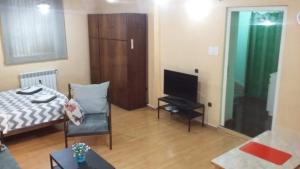 een woonkamer met een bed en een televisie bij Hotel House On Zubalashvili in Tbilisi City