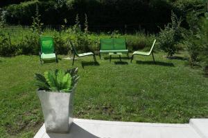 trois chaises vertes assises dans l'herbe dans une cour dans l'établissement Loft à La Campagne, à Parmilieu